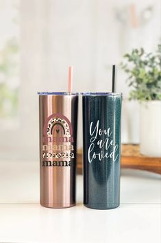 two personalized tumblers sitting next to each other on top of a white counter