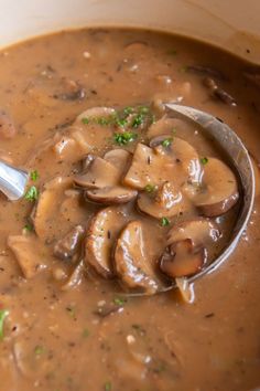 a spoon full of soup with mushrooms in it