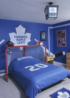 a bedroom decorated in blue and white with a hockey jersey on the bed