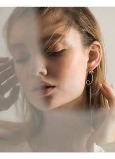 a woman with her eyes closed wearing gold earrings