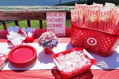 the table is set up with red plastic containers and white paper straws in them