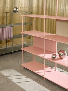 a pink shelf with three balls on it