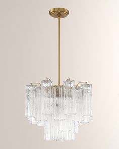 a chandelier with many clear glass pieces hanging from it's brass frame