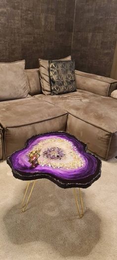 a couch and table in a room with pillows on the floor, one is shaped like an agate purple agate stone