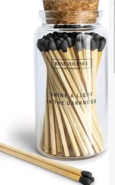 a jar filled with matches and two sticks