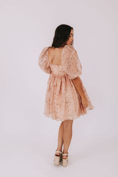 Bring a touch of vintage charm to your wardrobe with our Place In Time Dress! In a soft pale peach color, this dress features a whimsical floral print and a flattering babydoll style with puff sleeves and a square neckline. The elastic shoulder straps ensure a comfortable fit, while the crochet trim adds a unique touch. Fully lined for coverage, this mini dress also has sheer sleeves and an invisible zipper in the back. Perfect for any occasion, this dress is a must-have for any fashion-forward Feminine Beige Puff Sleeve Dress With Square Neck, Feminine Flowy Puff Sleeve Dress With Square Neck, Flowy Feminine Puff Sleeve Dress, Feminine Flowy Puff Sleeve Dress, Nursing Friendly Tops, Nursing Friendly Dress, Plus Jumpsuit, Babydoll Style, Tank Top Long Sleeve