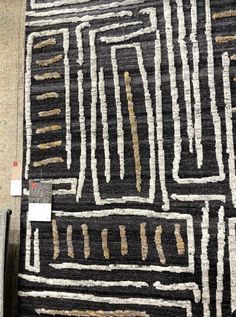 a black and white rug with gold lines on it