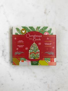 a red christmas book sitting on top of a white counter