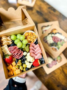 a person holding up a box filled with different types of food on it's side