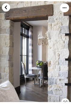 an open door leading to a living room with stone walls and wood trimmings