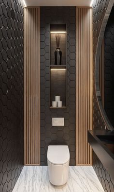 a modern bathroom with black and white tile on the walls, wood paneling around the toilet