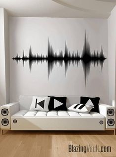 a white couch sitting in front of a wall with sound waves painted on it's side