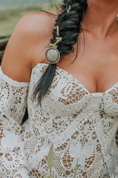 a woman with long hair wearing a white dress and holding a flower in her hand