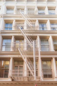 a fire escape on the side of a building with stairs leading up to it's second floor