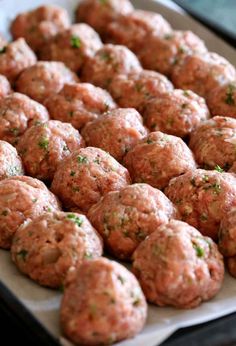 some meatballs are sitting on a baking sheet and ready to be cooked in the oven