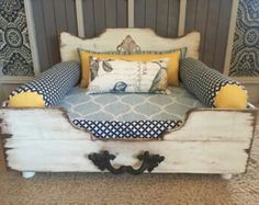 an upholstered bed with yellow and blue pillows