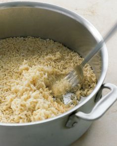 a pot filled with brown rice on top of a table