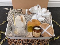 an open box with some items in it on the floor next to a white ribbon