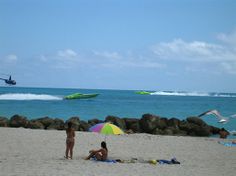 two people on the beach under an umbrella