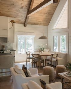 a living room filled with furniture next to a kitchen