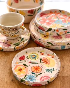 colorful floral plates and cups on a wooden table