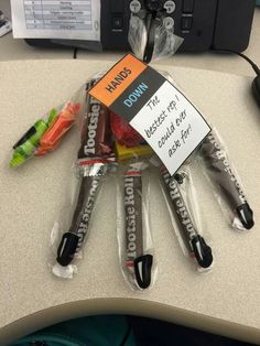 some candy wrapped in plastic on top of a desk with a sign that says, don't touch it