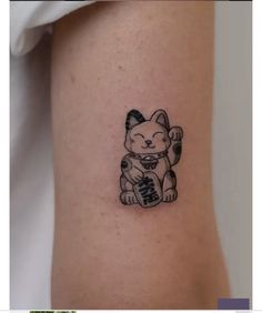 a small tattoo of a cat holding a bottle with the word boo on it's side