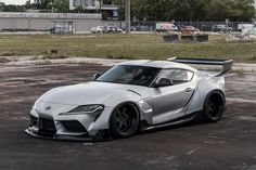 a white sports car parked in a parking lot