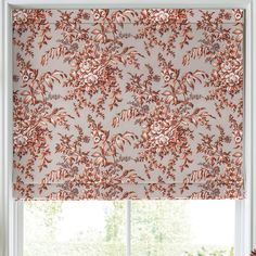 an orange and white roman blind in front of a window with pink flowers on it