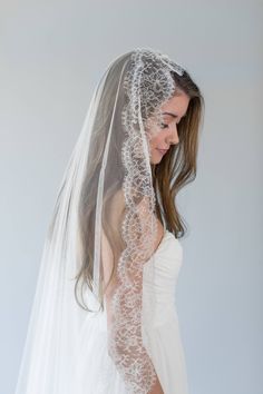 a woman wearing a wedding veil with lace