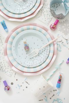 a table topped with plates and cups filled with confetti