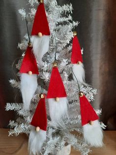 a white christmas tree decorated with red and white gnome hats