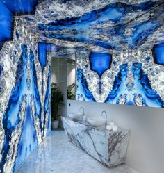 an artistic bathroom with blue and white marbles on the walls, along with two sinks