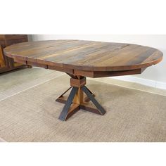 a large wooden table with two black legs and an oval shaped center piece on the top