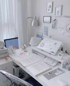 a white desk topped with lots of papers