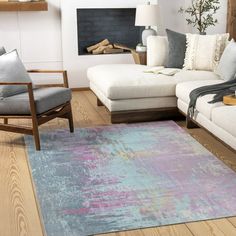 a living room filled with furniture and a rug on top of a hard wood floor