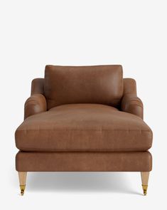 a brown leather chair with wooden legs