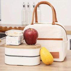 an apple sitting on top of a white lunch box