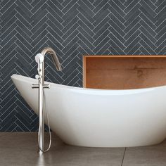 a white bath tub sitting on top of a tiled floor next to a wooden box