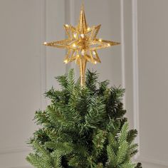 a gold star decoration on top of a christmas tree