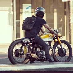 a man riding on the back of a motorcycle down a street