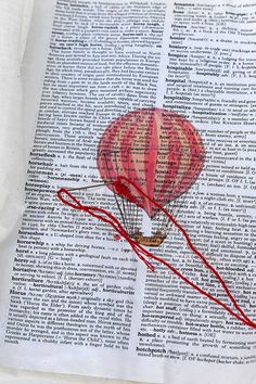 an image of a hot air balloon in the sky on top of a book page