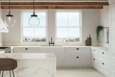 a kitchen with marble counter tops and white cabinets, along with an island in the middle