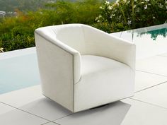 a white chair sitting on top of a tiled floor next to a pool