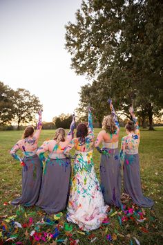 a group of women standing in the grass with confetti on their hands