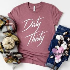 a t - shirt that says dirty thirty next to some scarves and other items