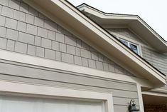 an image of a house with a garage door and window on the side of it