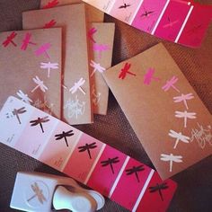 some cards with dragonflys on them are sitting next to a pair of scissors