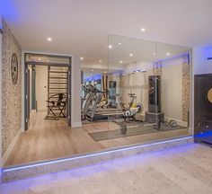 a home gym with mirrors and exercise equipment in the room that is lit up at night