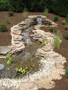 an outdoor garden with rocks and water features